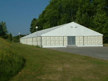 chapiteau aluminium avec panneaux rigides sur le pourtour et plancher